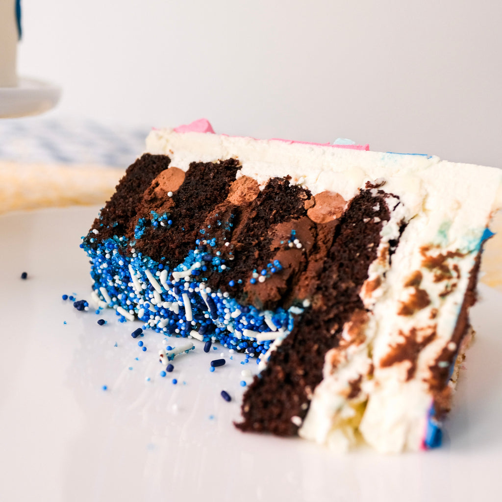 A slice of chocolate cake with blue sprinkles