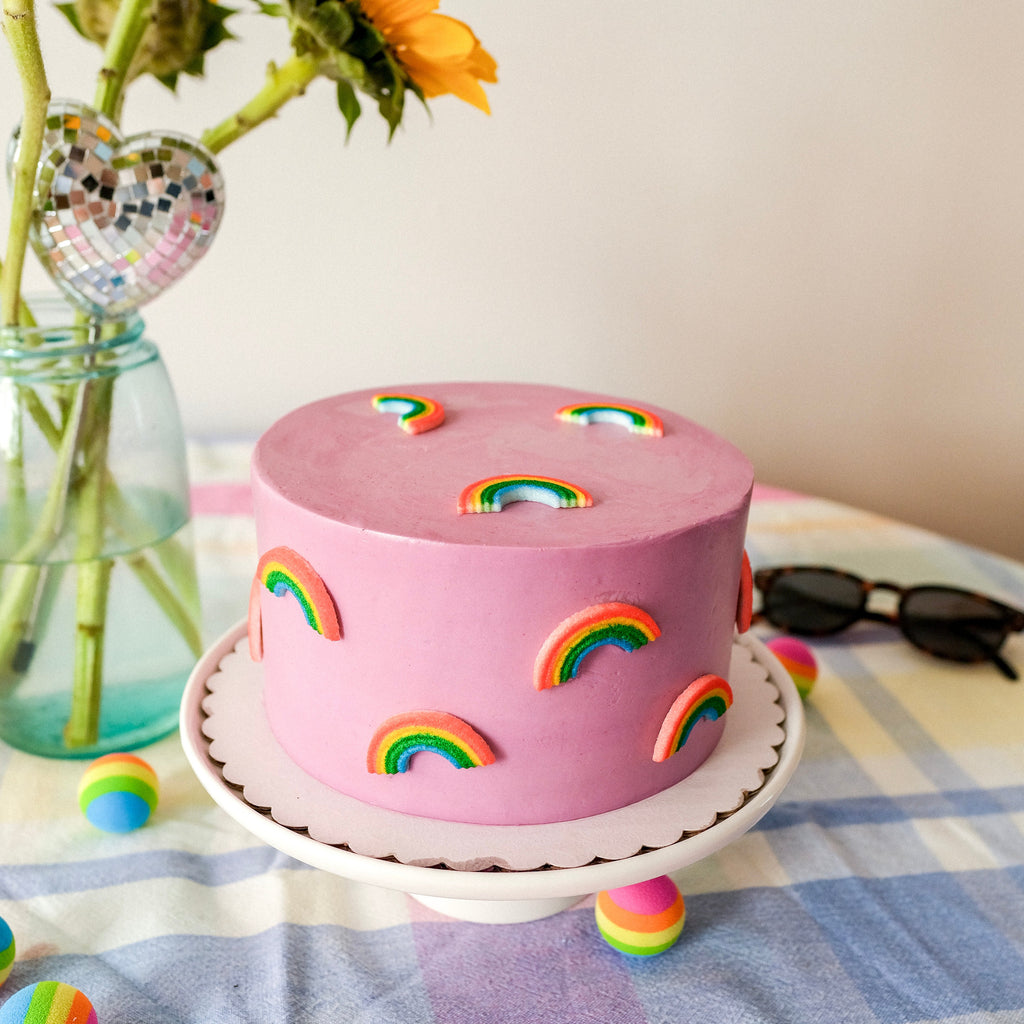 a purple cake with candy rainbows