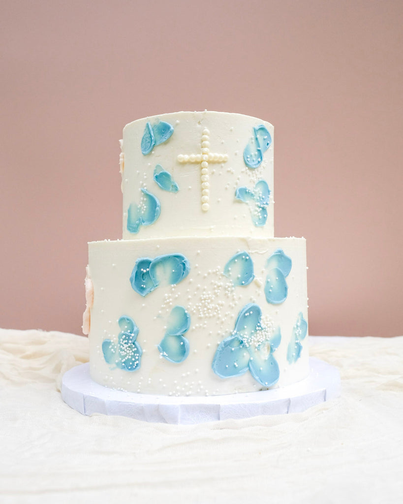 double tired blue floral baptism cake with white sprinkles
