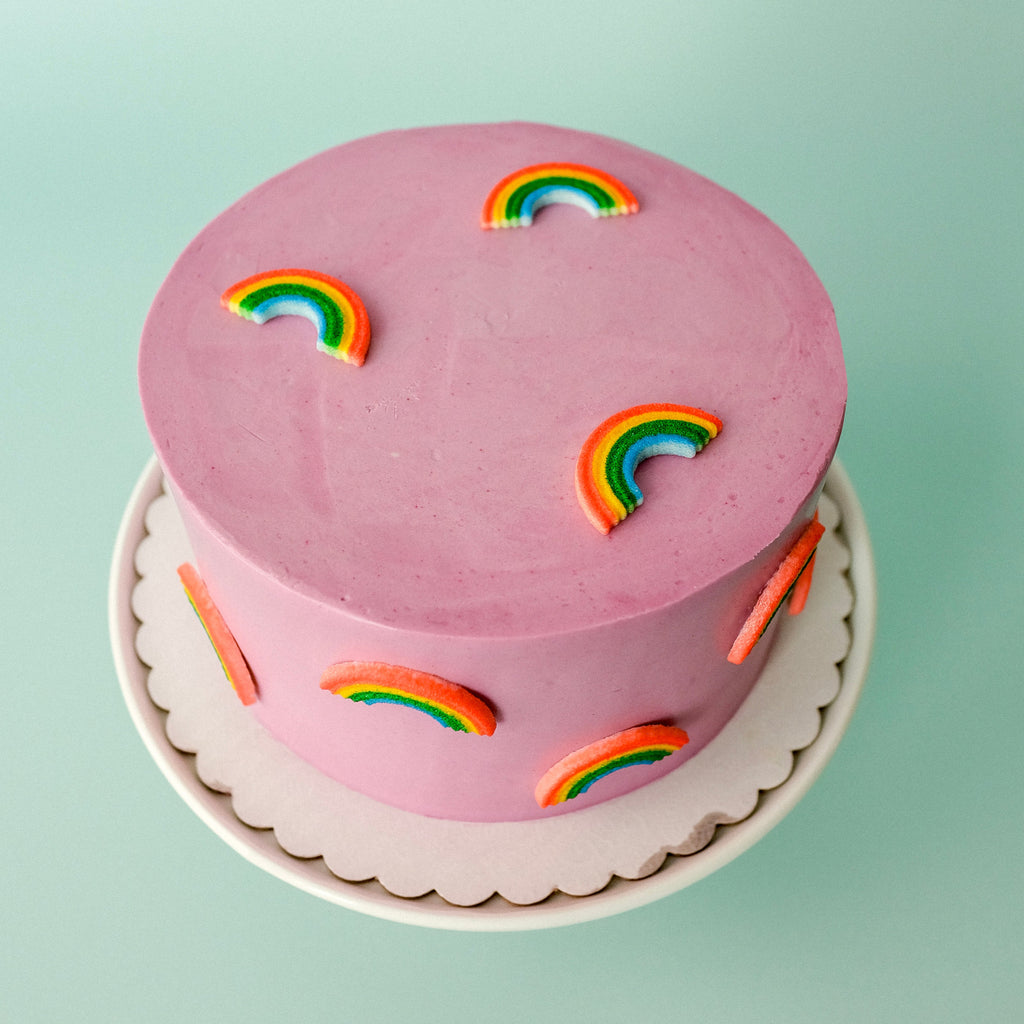 a purple cake with candy rainbows