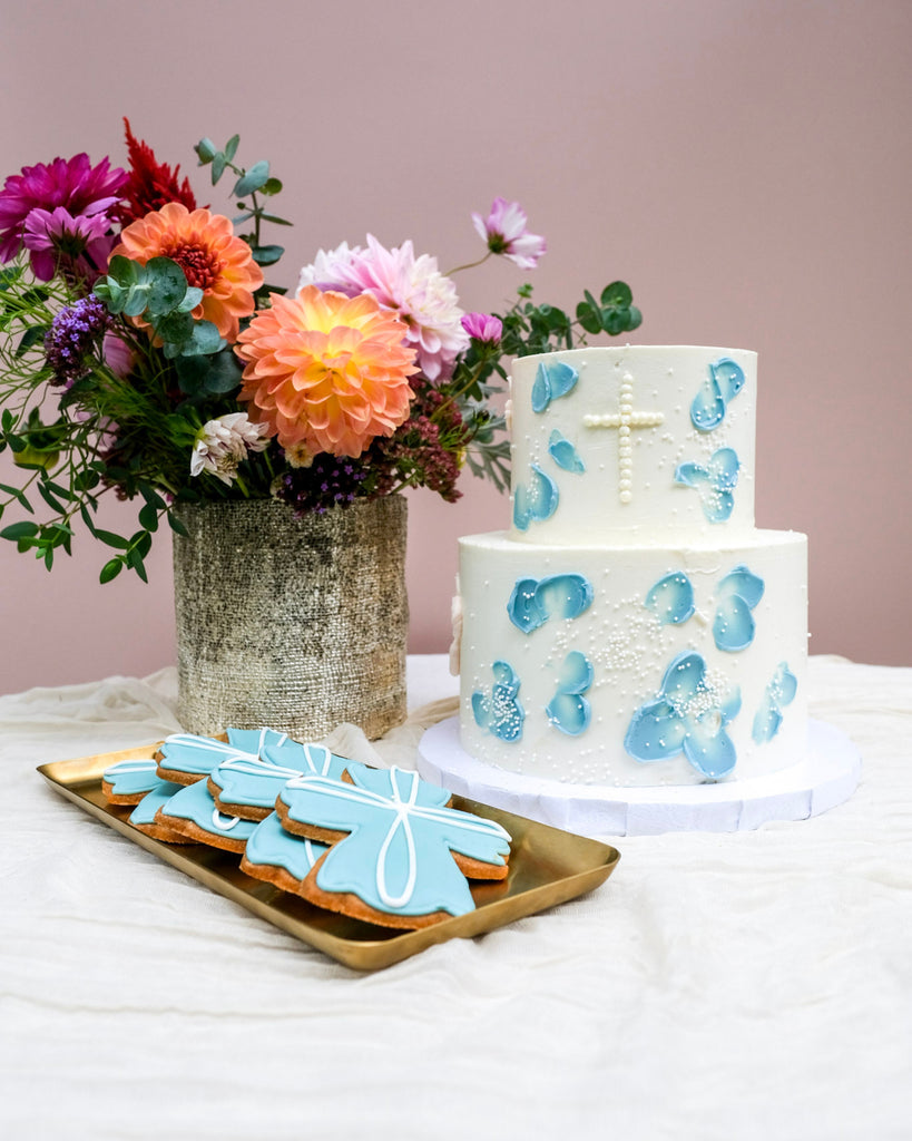 double tired blue floral baptism cake with white sprinkles and blue cross cookies 