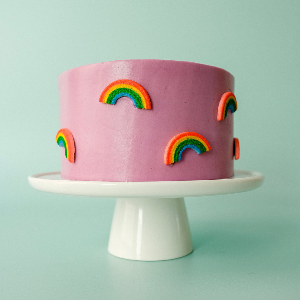 a purple cake with candy rainbows