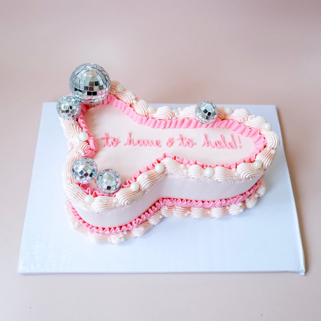 An ornate penis shaped bacholorette cake with pearls and disco balls. 