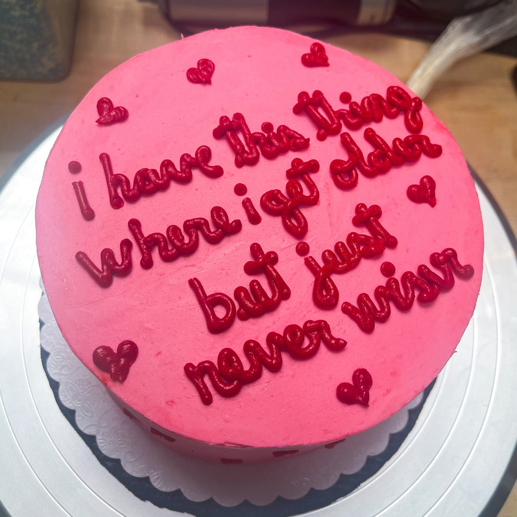 A pink cake with little red hearts