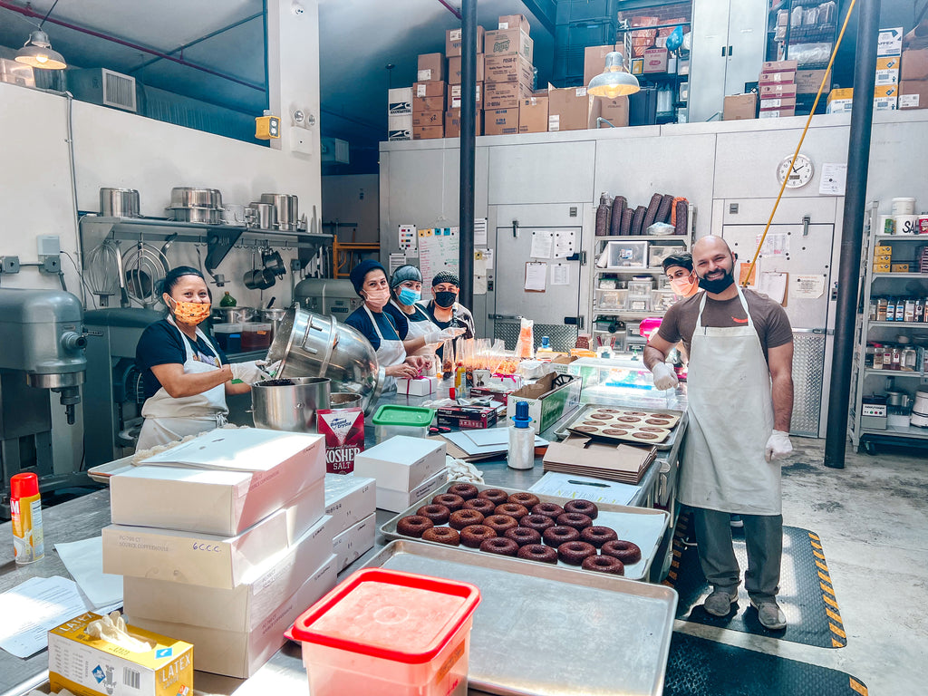 A picture of the Padoca Bakery cooks baking in the kitchen. 4 women and 2 men. 