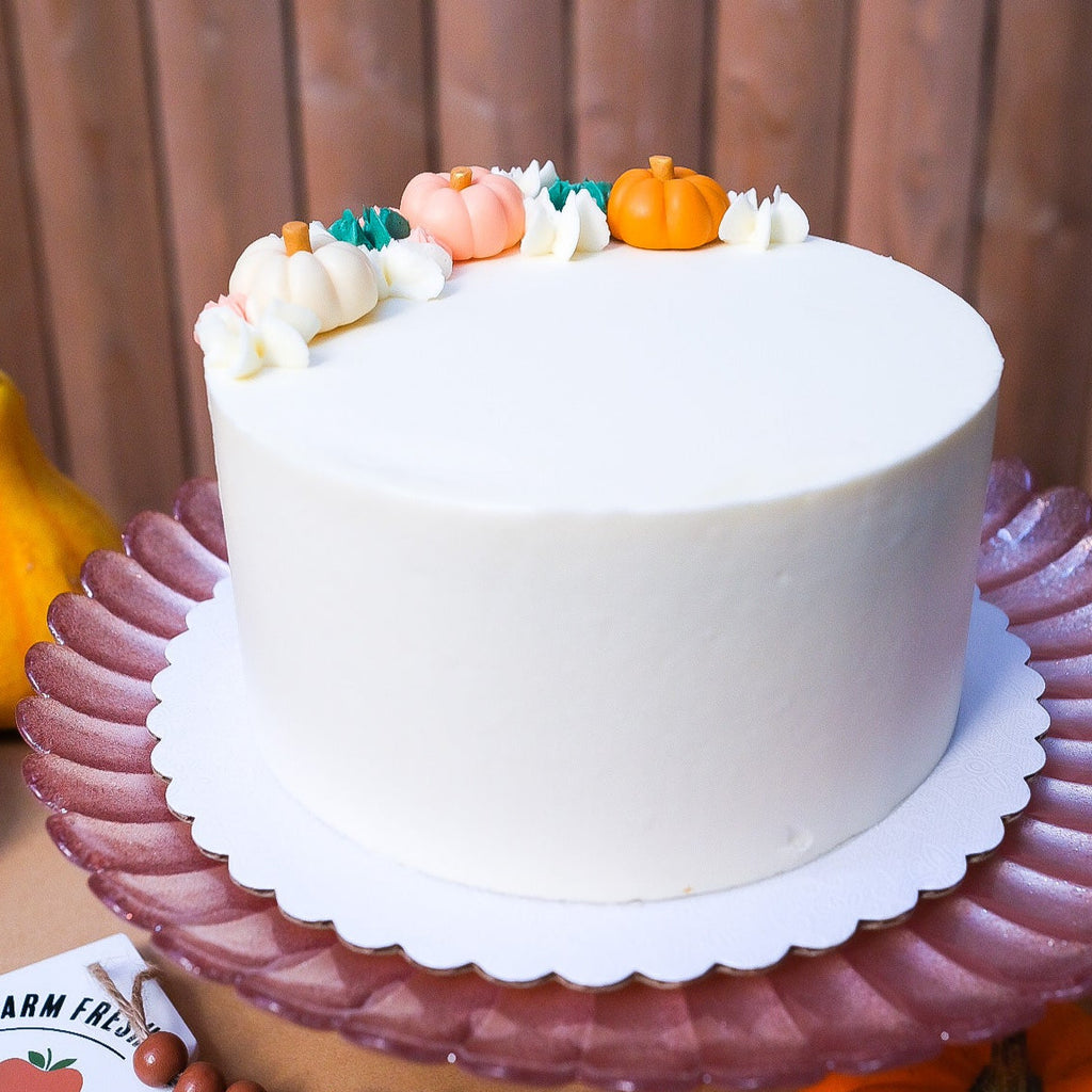 White cake with little pumpkins 
