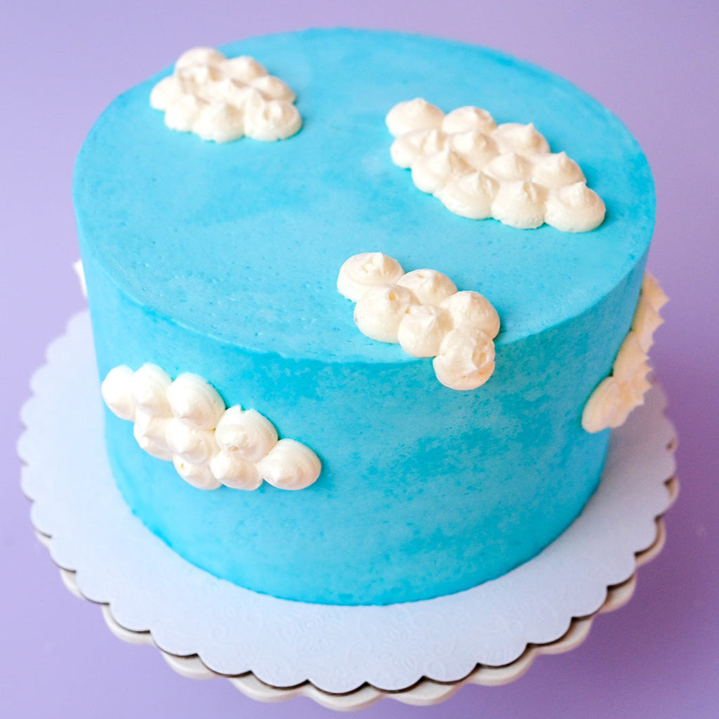 A blue cake decorated with clouds