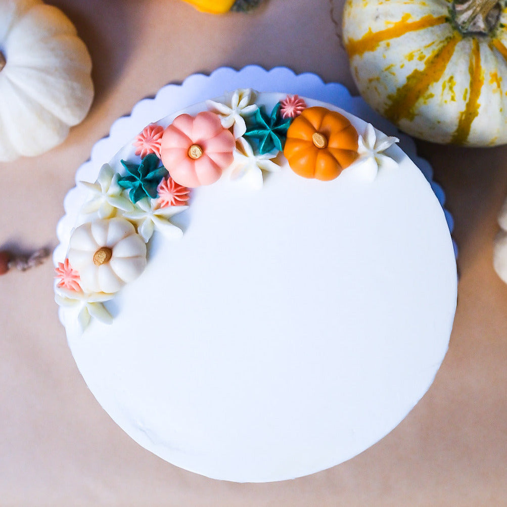 White cake with little pumpkins 