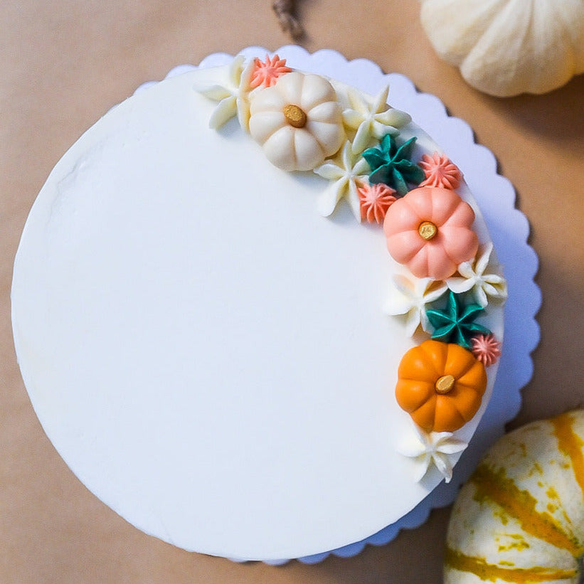 White cake with little pumpkins 