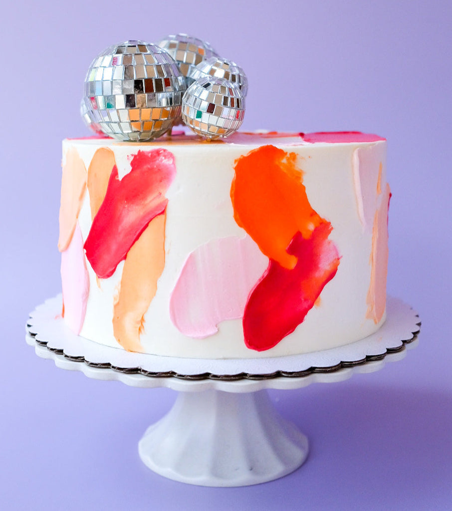 A pink, orange and red disco ball cake