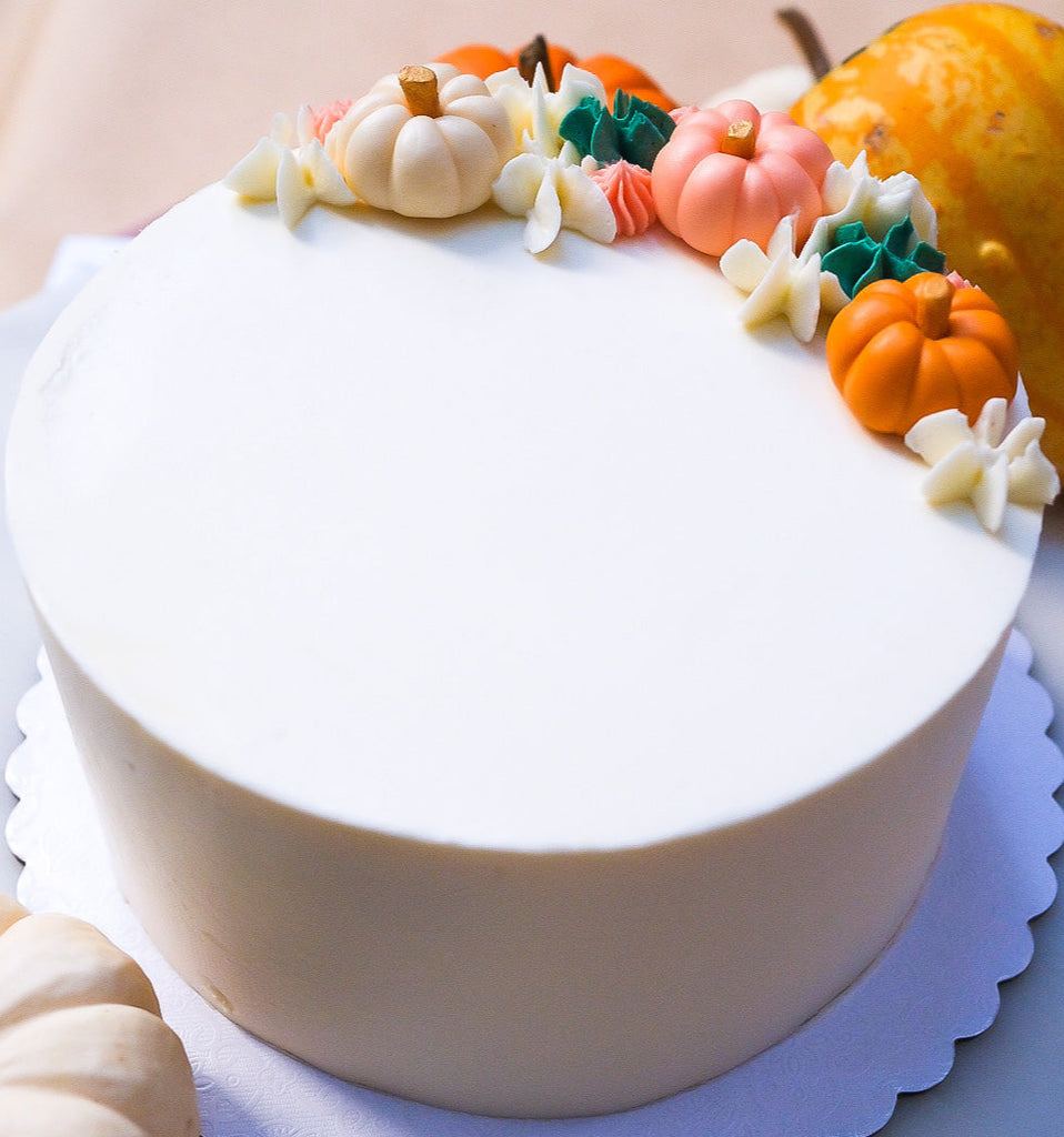 White cake with little pumpkins 