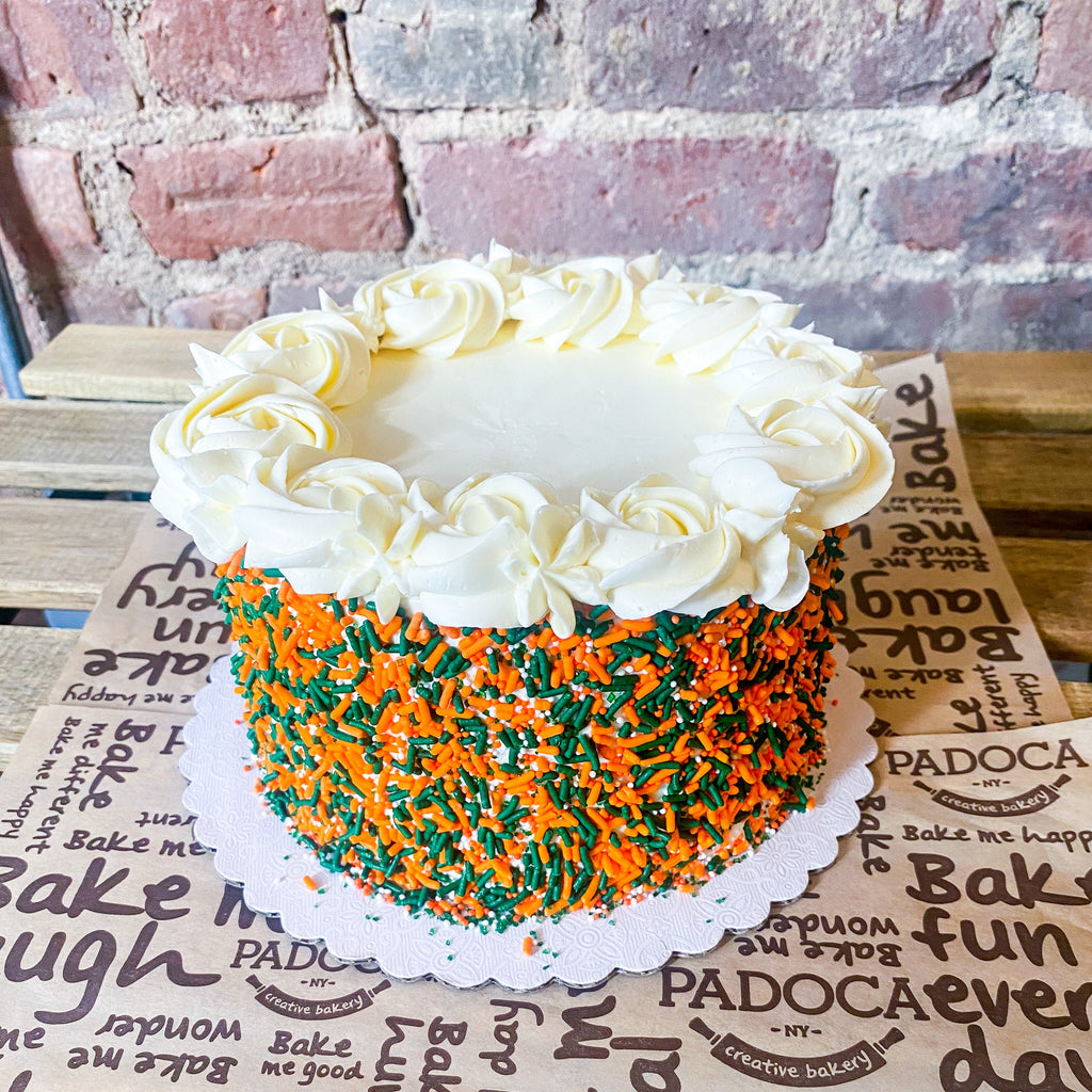 Orange and green classic sprinkle cake with rosettes on top 